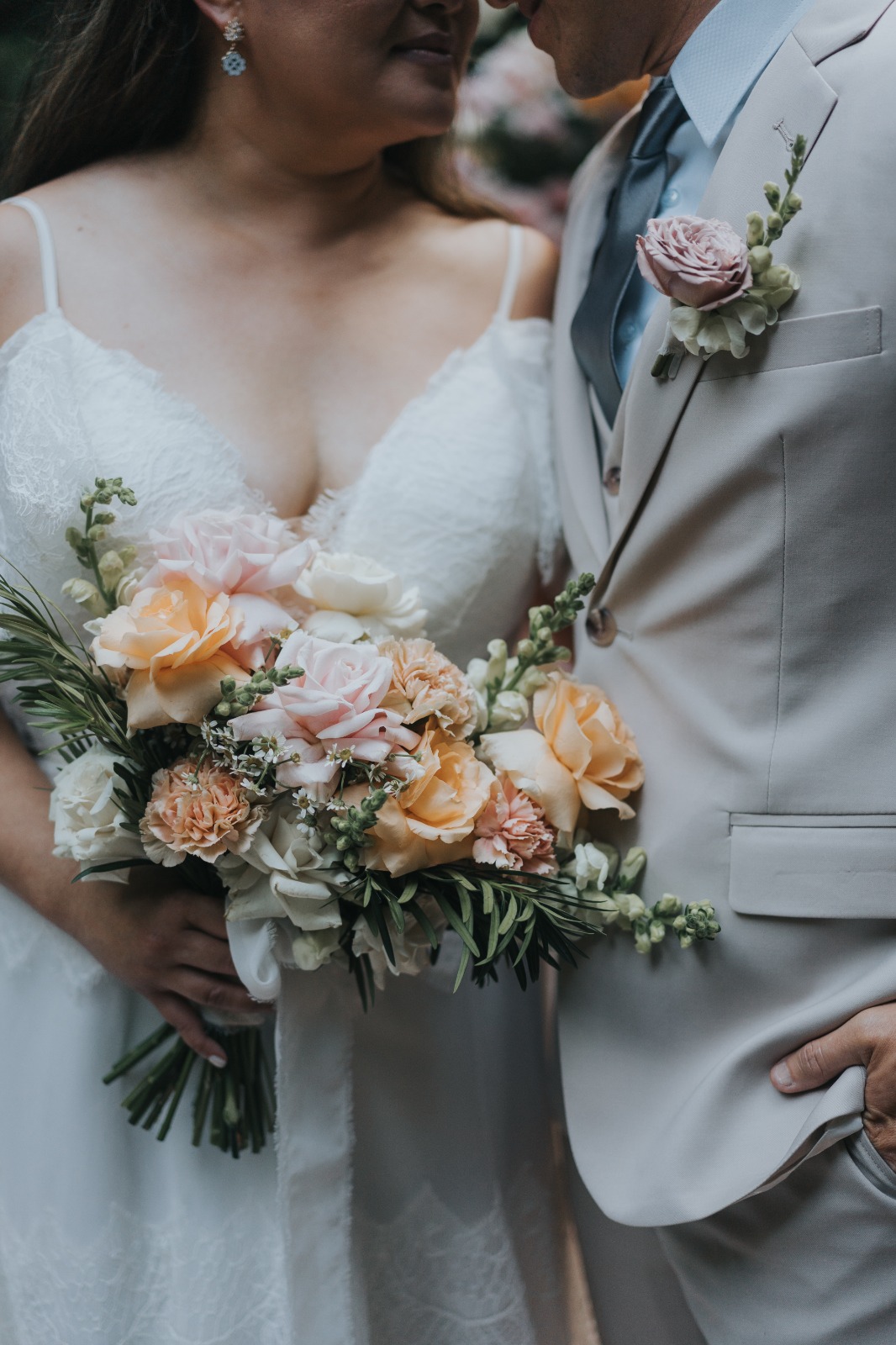 Bride kissing her groom while holding a white bridal bouquet by Lammar Flower Studio Bali