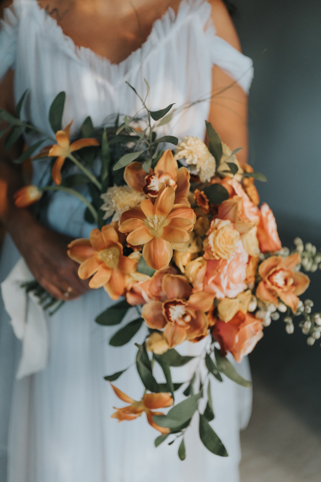 Bride kissing her groom while holding a white bridal bouquet by Lammar Flower Studio Bali