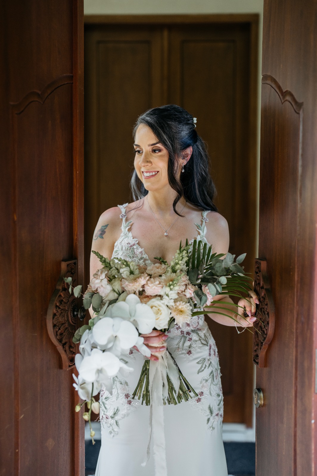 Bride kissing her groom while holding a white bridal bouquet by Lammar Flower Studio Bali