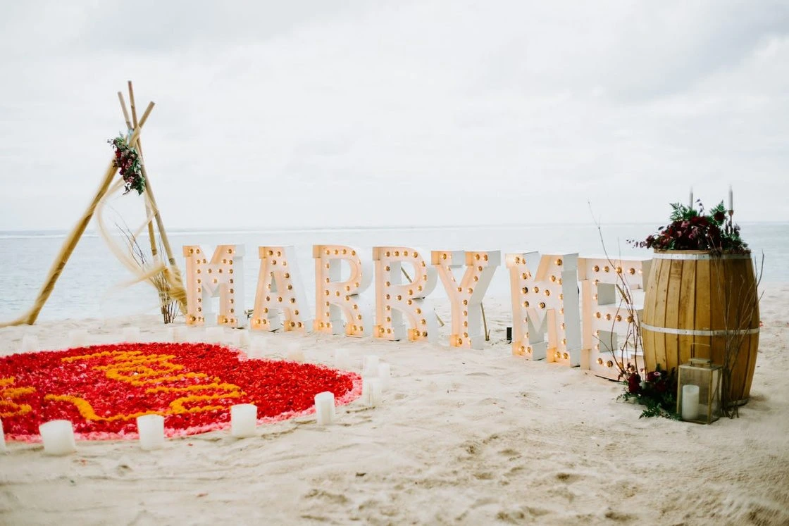Bride kissing her groom while holding a white bridal bouquet by Lammar Flower Studio Bali
